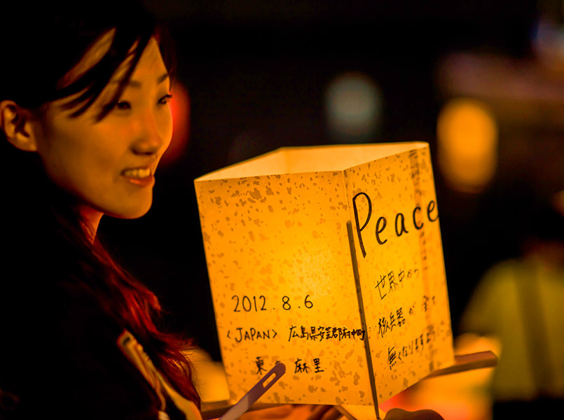 young woman holding a candle in a paper bag in Japan