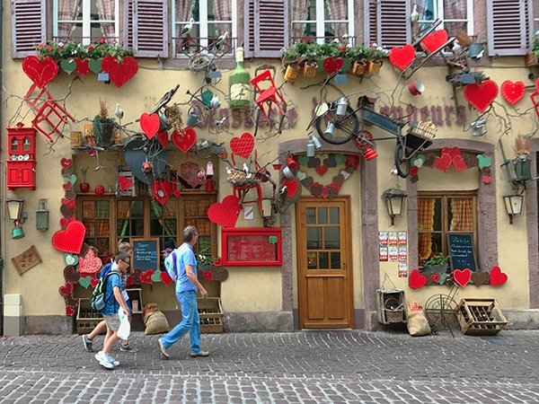 Foto Friday - people walking by a building with paper hearts hanging on it