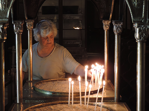 Foto Friday - a woman lighting a candle in a church