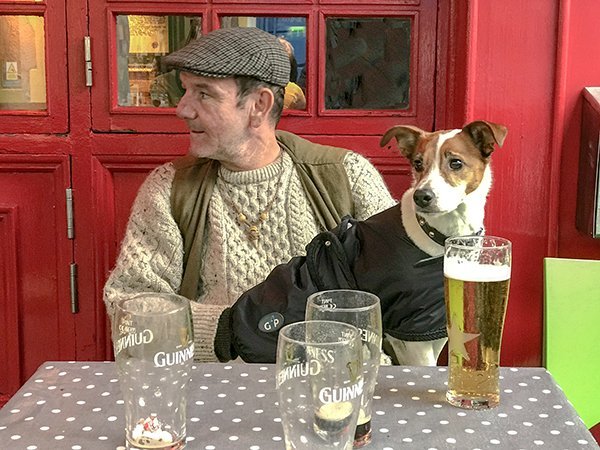 Foto Friday - an Irish man, with a dog in his lap, having a beer