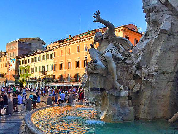 Foto Friday - people by a fountain near brightly colored buildings