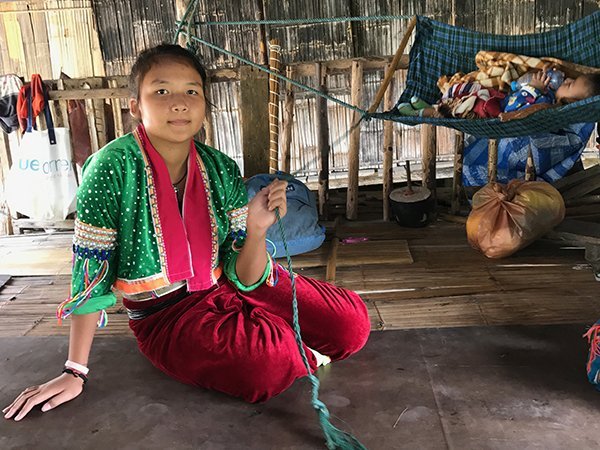 Foto Friday - a young girl inThai traditional dress rocking a baby