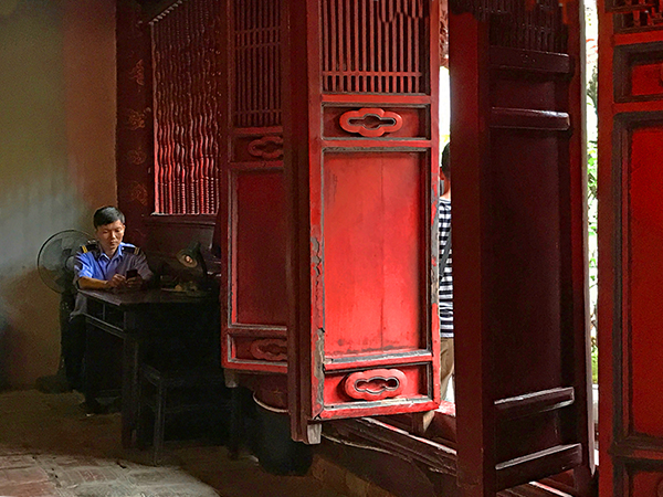 Foto Friday - a man sitting by bright-red shutters