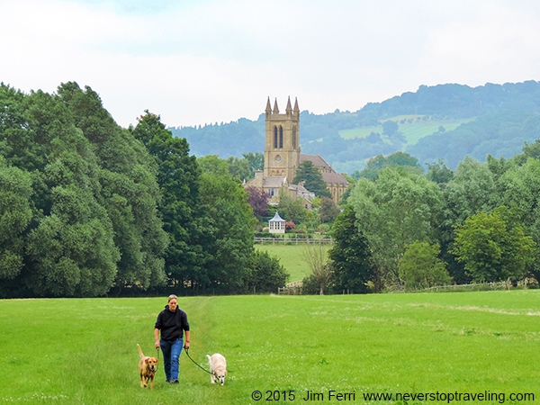 Foto Friday - a man with dogs walking across a field with a cathedral in teh background