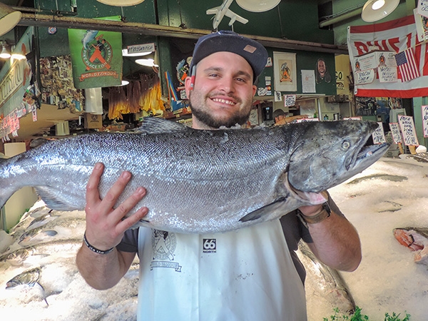 Foto Friday - a man holding a larhe fish in a market