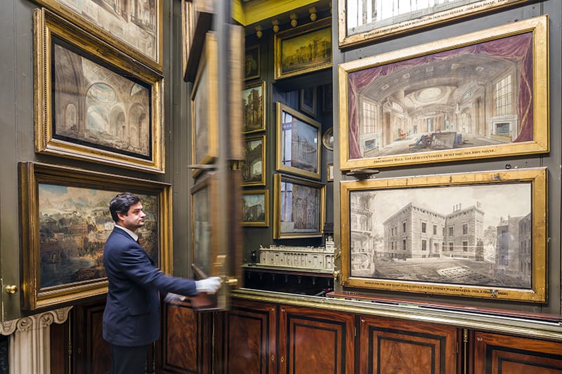 man with painings in the Sir John Soan Museum, one of the small London museums