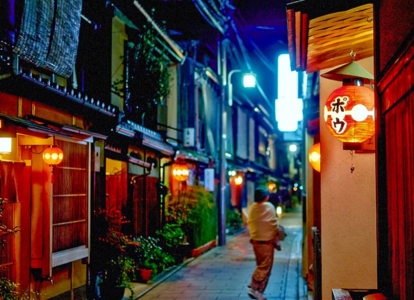 woman walking down a lane at night