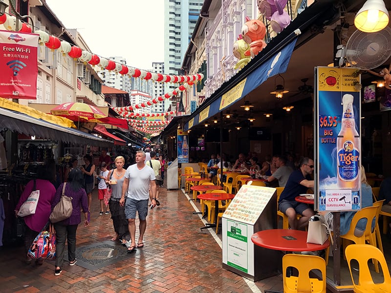 two people walking past restaurants