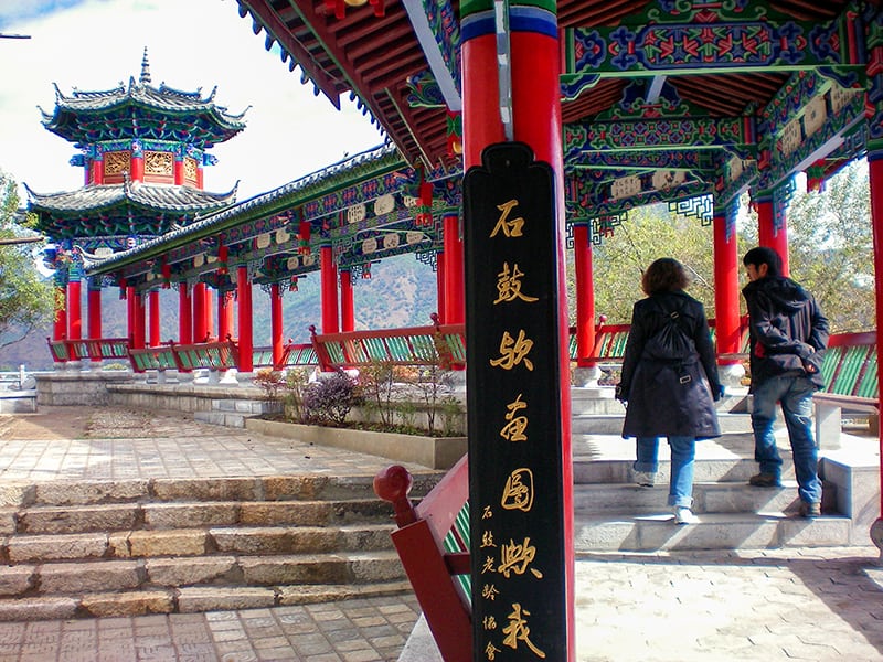 couple walking under an ornate overhang in Lijiang ,Yunnan, China