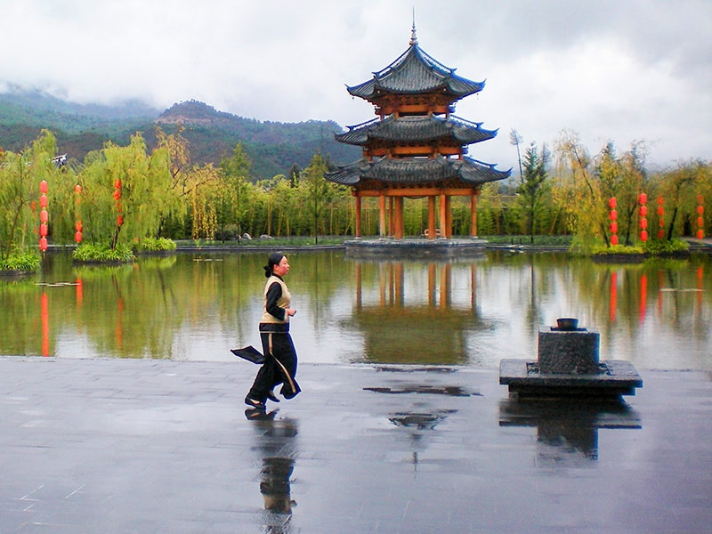 a woman and a pagoda in Lijiang Yunnan China