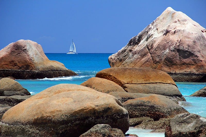 large rocks and a sailboat