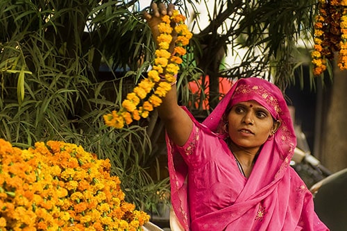 Woman holding flowers during Diwali - New Delhi travel tips