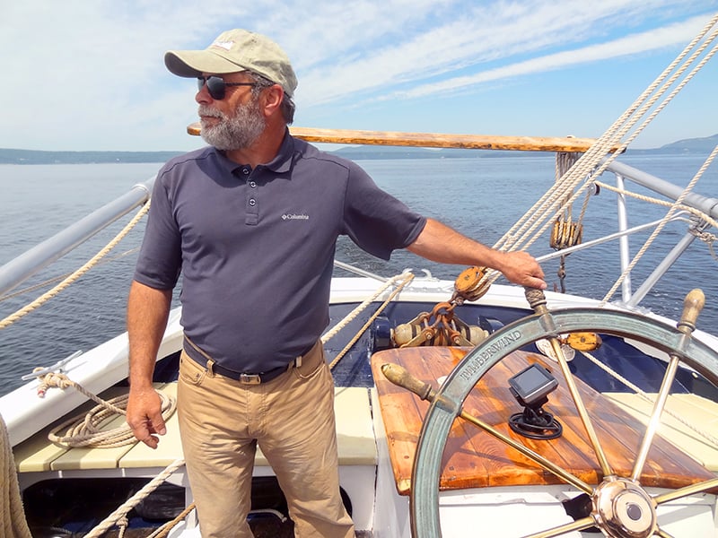 A Captain at the helm of one of the windjammers in maine