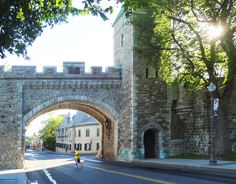 man walking by an old city wall