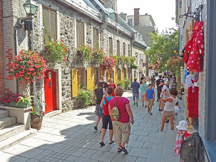 people on a street with old houses on a walking tour of Quebec City