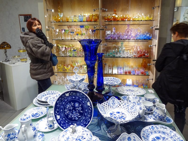 a woman in a shop selling colorful glass