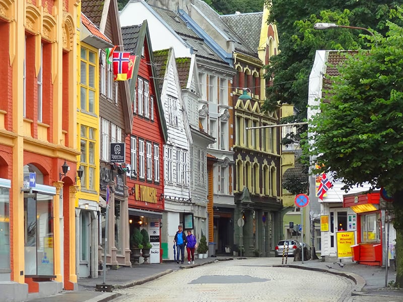 people walking along a street lined with old buildings in Bergen, Norway