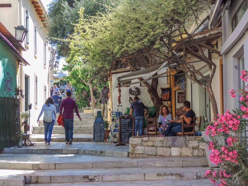 people sitting along a hilly street