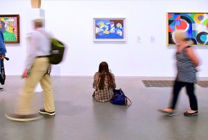 woman sitting on the floor of an art museum