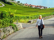 a woman walking through vineyards seen on a day trip from geneva