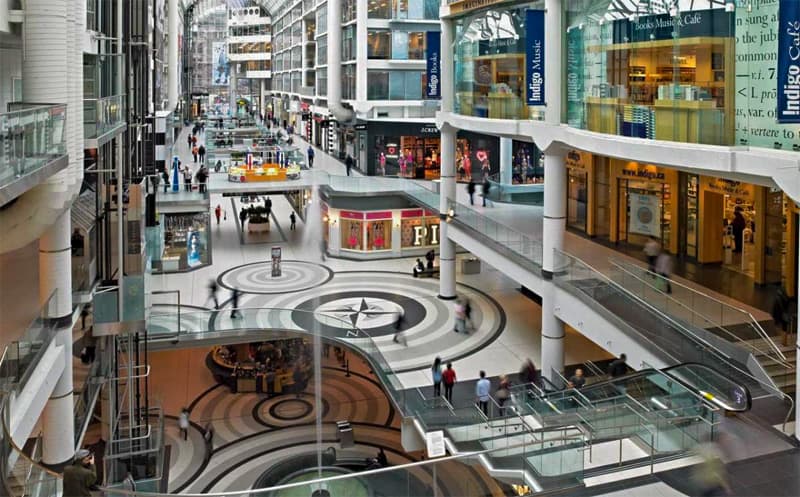 people walking past shops in a large mall