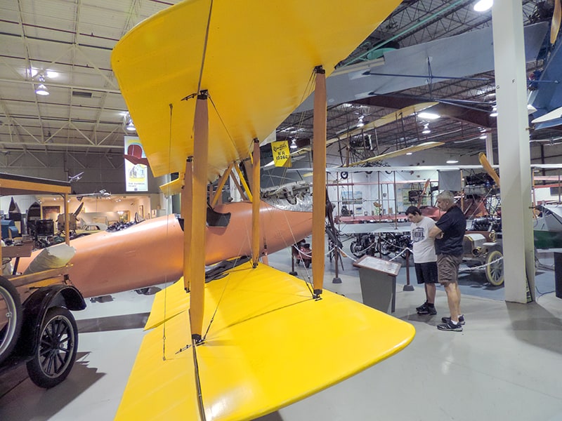 two men looking at an old airplanes in a hanger  - one of the things to do in the finger lakes