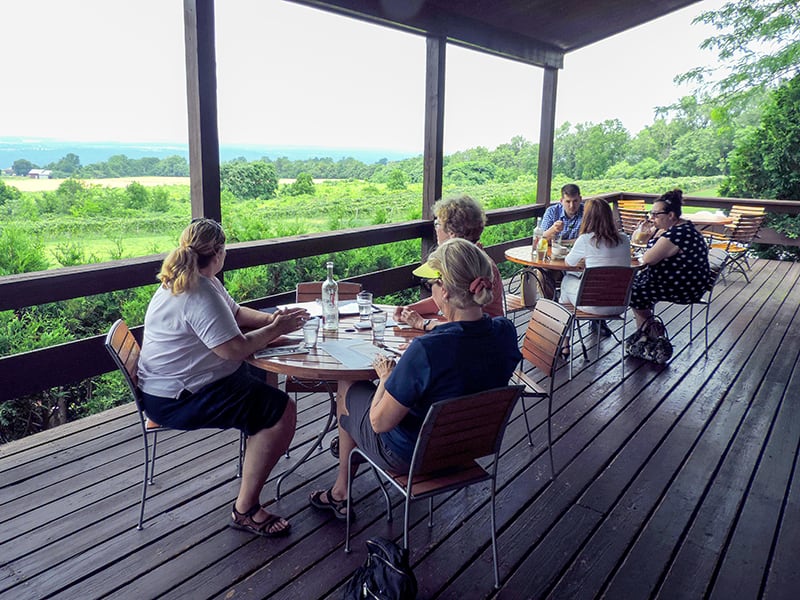 people eating lunch on a large porch