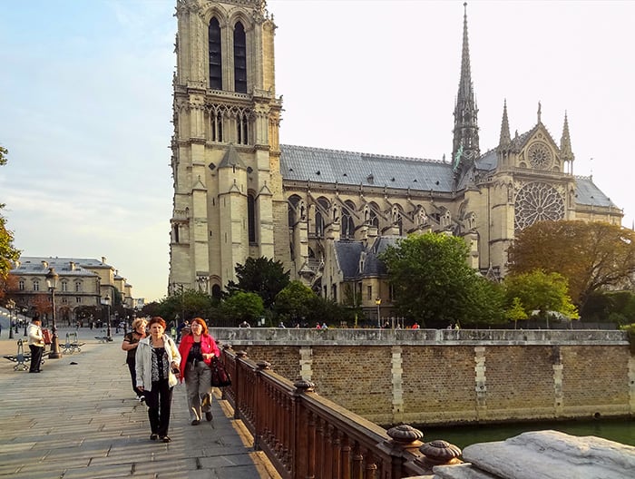 people passing Notre Dame during their walks in Paris