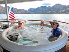 three people sitting in a hot tub on a ship in Galapagos