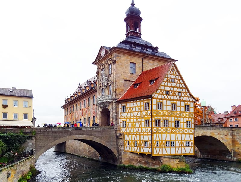 people on a bridge looking at old buildings in one of the best German towns to visit