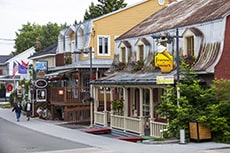 people walking through a charming old town near the Saguenay Fjord