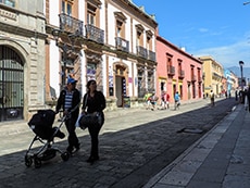 people walking along a colorful colonial street