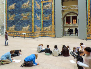 children on the floor in a museum drawing pictures of an exhibit