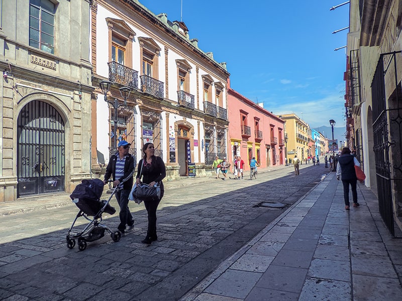 a couple pushing a baby carriage aong a street