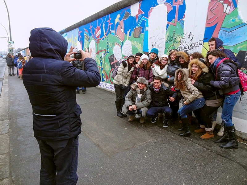 a group being photographed in front of the Berlin Wall, one of the things to see in Berlin