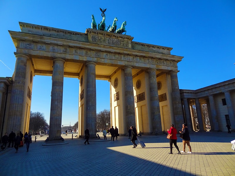 people walking through an old city gate, one of the things to see in Berlin