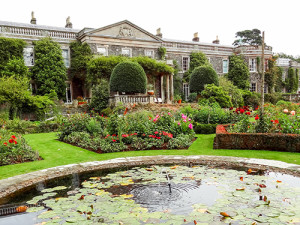 a garden and a pool by an old mansion