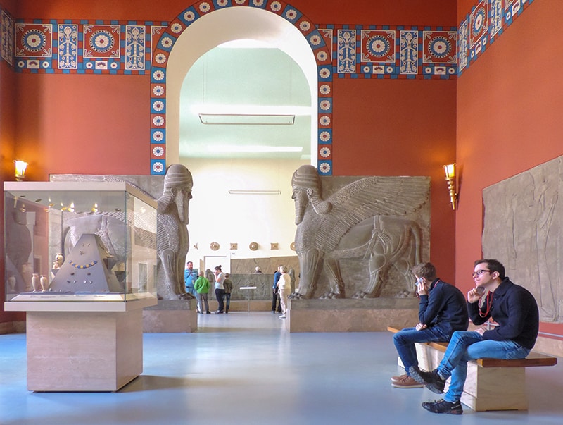 people sitting in a museum with large sculptures, one of the things to see in Berlin