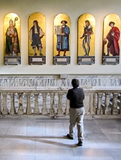 man looking at statues in a museum