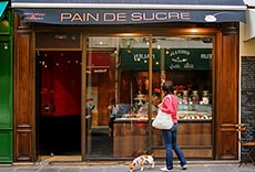 a woman looking into a pastry shop window