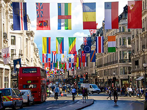 brighlty colored flags hanging over a city street