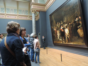 people looking at a painting in a museum