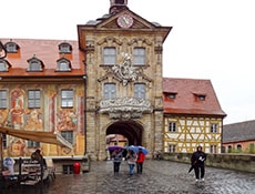 people walking past an old European painted building