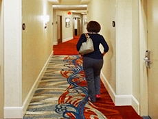 a woman walking down a hotel hallway