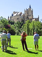 people looking up at a castle