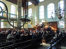 Men sitting in pews in a synagopgue