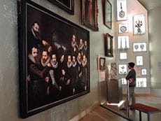 young man looking at a large painting in a museum