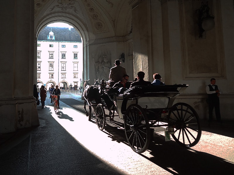 a horsedrawn carriage under an archway