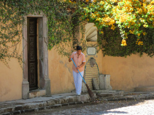 woman sweeping the sidewalk
