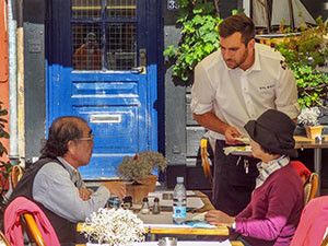 waiter speaking with two diners